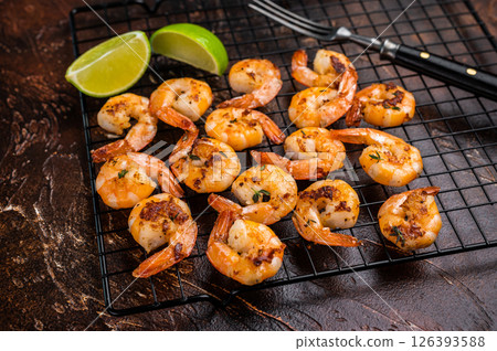 Grilled Shrimps Prawns with garlic on a rack. Brown background. Top view Grilled Shrimps Prawns with garlic on a rack. Brown background. Top view 126393588