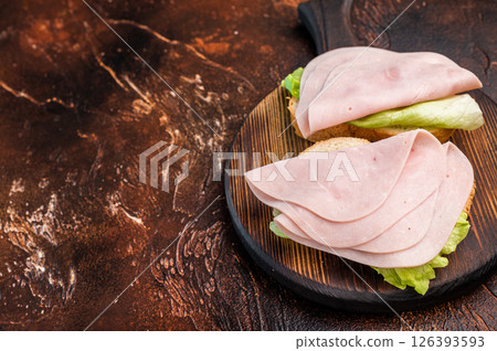 Colorful ham sandwich bursting with flavor and freshness, perfect for lunchboxes or casual dining. brown background. top view 126393593