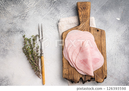 Delicious slices of cured ham on a wooden platter, ideal for entertaining and adding flavor to your dishes. white background. top view Delicious slices of cured ham on a wooden platter, ideal for entertaining and adding flavor to your dishes. white background. top view 126393598