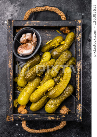 Sweet and tangy pickled cucumbers, ideal for enhancing burgers and wraps with a burst of flavor. black background. top view Sweet and tangy pickled cucumbers, ideal for enhancing burgers and wraps with a burst of flavor. black background. top view 126393613