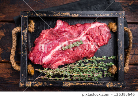 Uncooked hanging tender beef steak, Hanger steak in wooden tray with herbs. wooden background. top view Uncooked hanging tender beef steak, Hanger steak in wooden tray with herbs. wooden background. top view 126393646