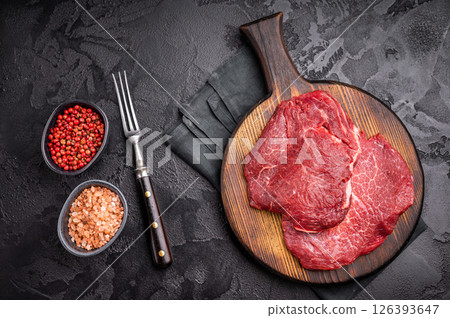 Butcher board with raw beef cheeks, uncooked meat. black background. top view Butcher board with raw beef cheeks, uncooked meat. black background. top view 126393647