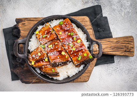 Japanese Cuisine Unadon, grilled unagi eel with rice in a skillet. white background. top view 126393773