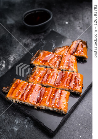 Unagi kabayaki eel, japanese grilled fish fillet with sauce. black background. top view Unagi kabayaki eel, japanese grilled fish fillet with sauce. black background. top view 126393792