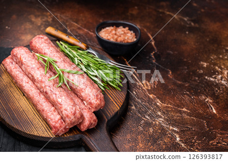 Fresh raw beef and lamb meat kebabs sausages on wooden board. brown background. top view 126393817