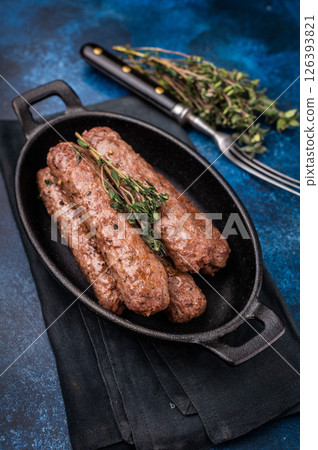 Grilled Cevapcici Sausage, roasted Cevapi from mince beef and pork meat in a skillet. blue background. top view 126393821