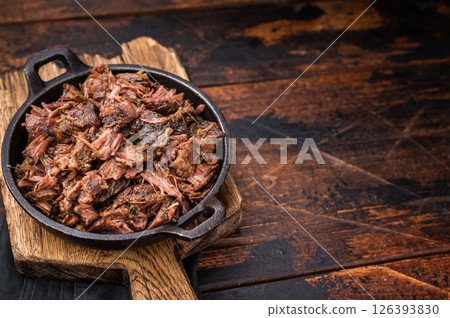 Traditional Barbecue smoked beef meat, pulled beef in a skillet. wooden background. top view Traditional Barbecue smoked beef meat, pulled beef in a skillet. wooden background. top view 126393830