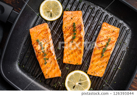 Pan fried salmon fillet steaks with thyme and lemon, fresh fish. wooden background. top view 126393844