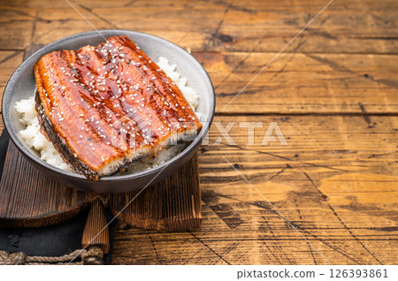 Unagi don or Japanese grilled eel rice in a bowl. wooden background. top view Unagi don or Japanese grilled eel rice in a bowl. wooden background. top view 126393861