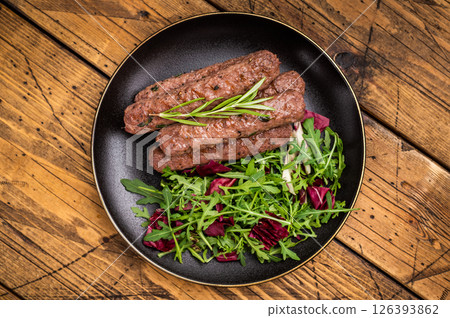 Balkan BBQ roast Cevapcici Sausage, roasted Cevapi from mince beef and pork meat. wooden background. top view Balkan BBQ roast Cevapcici Sausage, roasted Cevapi from mince beef and pork meat. wooden background. top view 126393862
