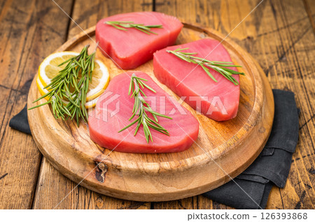 High quality raw tuna steak loin, perfect for a refreshing poke bowl or a delicious seared dish that impresses every time. wooden background. top view High quality raw tuna steak loin, perfect for a refreshing poke bowl or a delicious seared dish that impresses every time. wooden background. top view 126393868