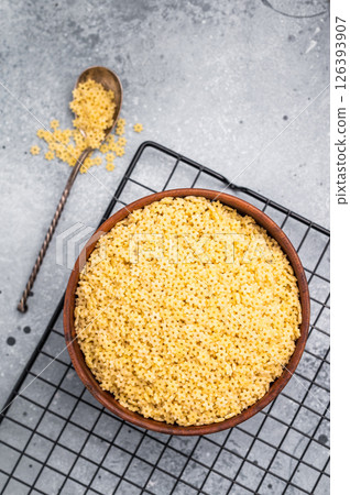 Raw stelline pasta, uncooked Italian soup Noodle in a bowl. grey background. top view 126393907