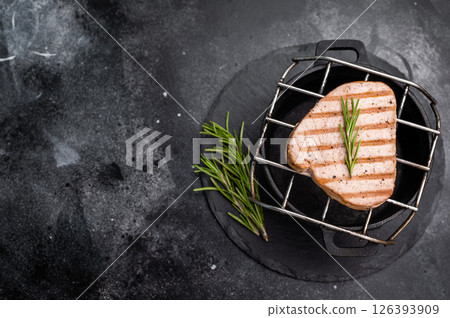 Juicy grilled tuna steak, perfectly seared with a smoky flavor, ideal for seafood lovers and gourmet dishes. black background. top view Juicy grilled tuna steak, perfectly seared with a smoky flavor, ideal for seafood lovers and gourmet dishes. black background. top view 126393909
