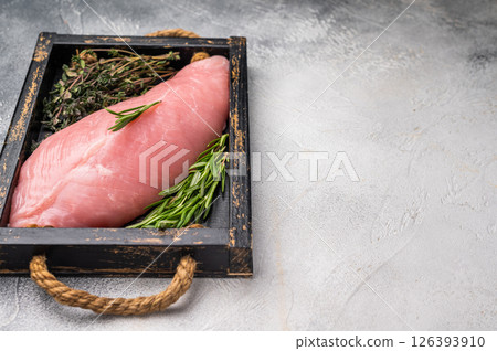 Raw poultry meat, fresh turkey breast fillet with herbs for cooking. grey background. top view Raw poultry meat, fresh turkey breast fillet with herbs for cooking. grey background. top view 126393910