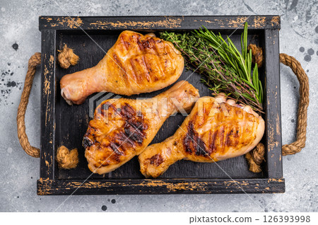 Flavorful chicken drumsticks legs, expertly cooked over an open flame, perfect for serving at family gatherings or picnics. grey background. top view Flavorful chicken drumsticks legs, expertly cooked over an open flame, perfect for serving at family gatherings or picnics. grey background. top view 126393998