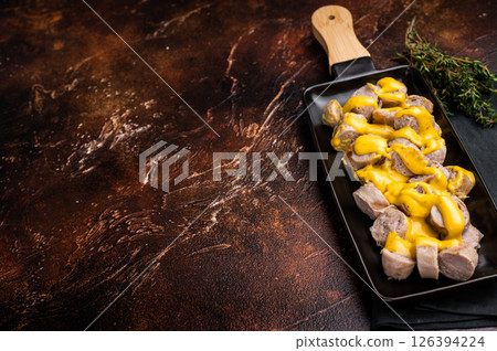 BBQ Grilled and sliced Sausages with cheese and mustard sauce in plate. brown background. top view 126394224