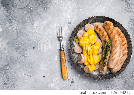 Grilled Bratwurst Sausages with cheese sauce in plate. grey background. top view 126394232