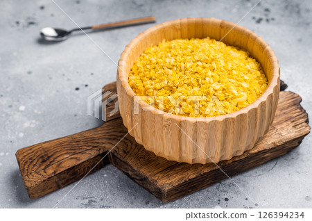 Millet flakes in wooden bowl, rolled millet for porridge and muesli. grey background. top view Millet flakes in wooden bowl, rolled millet for porridge and muesli. grey background. top view 126394234