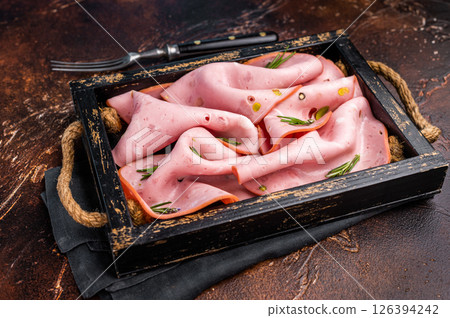Mortadella Bologna slices with pistachios for breakfast in wooden. brown background. top view 126394242