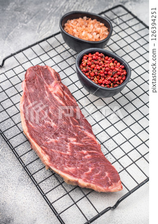 Fresh raw top sirloin steak, showcasing its rich color and marbling. grey background. top view Fresh raw top sirloin steak, showcasing its rich color and marbling. grey background. top view 126394251