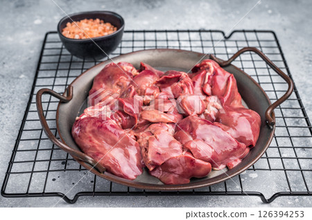 Raw poultry liver, chicken offals beautifully displayed, ready for seasoning. A nutritious ingredient ideal for gourmet dishes and traditional recipes. grey background. top view Raw poultry liver, chicken offals beautifully displayed, ready for seasoning. A nutritious ingredient ideal for gourmet dishes and traditional recipes. grey background. top view 126394253