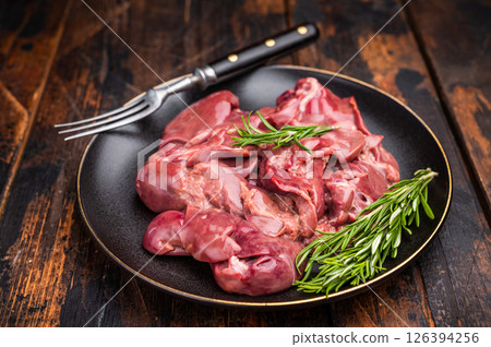 Raw chicken liver, featuring a glossy sheen and rich hue. A versatile ingredient that brings bold flavors to any culinary creation. wooden background. top view Raw chicken liver, featuring a glossy sheen and rich hue. A versatile ingredient that brings bold flavors to any culinary creation. wooden background. top view 126394256
