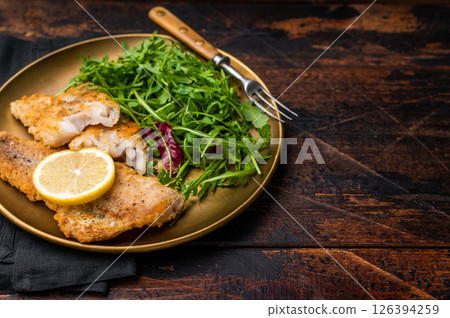 Roasted Pollock fish fillet on a plate with salad. wooden background. top view 126394259