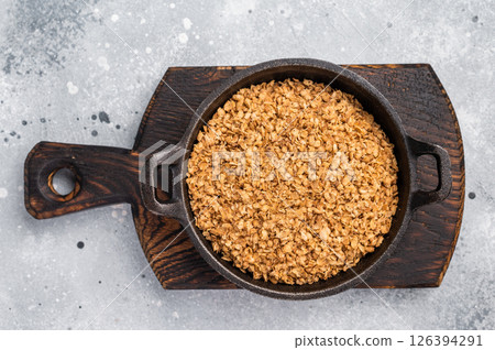 Raw buckwheat flakes in a skillet. grey background. top view 126394291