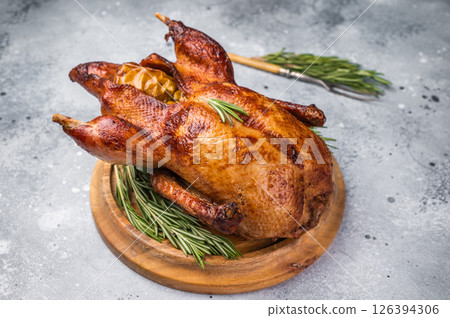 Baked whole duck with apples on wooden board. grey background. top view Baked whole duck with apples on wooden board. grey background. top view 126394306
