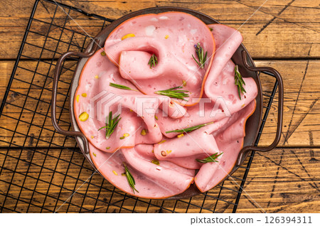 Mortadella sausage slices with pistachios for sandwiches in steel tray. wooden background. top view 126394311