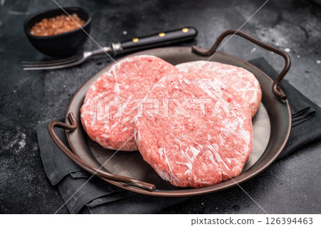 Frozen Meat cutlet, mincemeat of pork and beef for burgers. black background. top view Frozen Meat cutlet, mincemeat of pork and beef for burgers. black background. top view 126394463