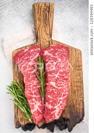 Juicy raw shoulder denver steak, highlighting its tenderness and quality. Perfect for marinating or slow-cooking to enhance its delicious flavor. grey background. top view 126394465