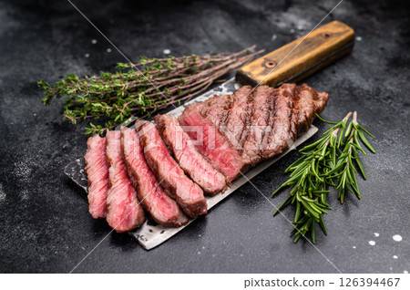 Savory shoulder steak Denver, beautifully cooked on the grill, highlighting its marbled texture and succulent taste. black background. top view Savory shoulder steak Denver, beautifully cooked on the grill, highlighting its marbled texture and succulent taste. black background. top view 126394467