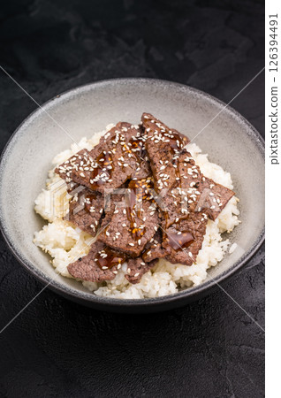 Yakiniku, wagyu marbled beef cuts and rice in a bowl. A culinary journey that captures the essence of Japanese grilling traditions. black background. top view 126394491