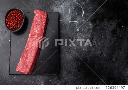 Exquisite raw wagyu beef, showcasing its rich marbling and vibrant color, perfect for gourmet dishes or high-end grilling experiences. black background. top view 126394497