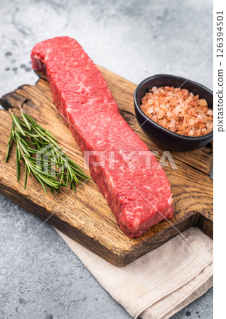 Juicy raw Kobe style beef, renowned for its exceptional flavor and tenderness. Perfect for preparing mouthwatering steaks or sashimi. grey background. top view 126394501