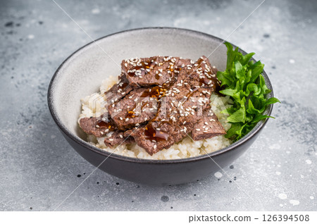 Delectable yakiniku feast, featuring a variety of marbled beef cuts and rice. A culinary journey that captures the essence of Japanese grilling traditions. grey background. top view 126394508