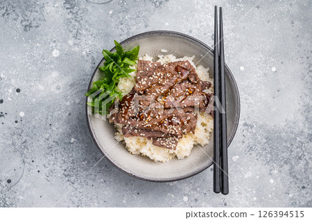 Delectable yakiniku feast, featuring a variety of marbled beef cuts and rice. A culinary journey that captures the essence of Japanese grilling traditions. grey background. top view 126394515