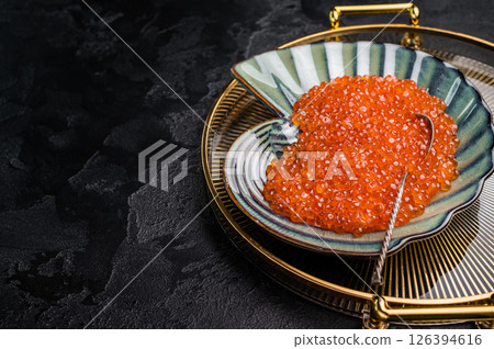 Bright red caviar, a gourmet delight that adds a burst of flavor to any dish or celebration. grey background. top view Bright red caviar, a gourmet delight that adds a burst of flavor to any dish or celebration. grey background. top view 126394616