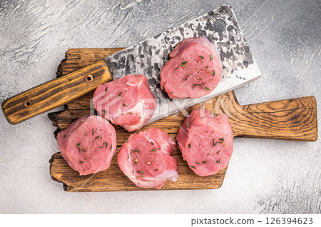 Juicy uncooked pork medallion, raw loin meat a versatile choice for stir fries or savory roasts in any cuisine. white background. top view 126394623