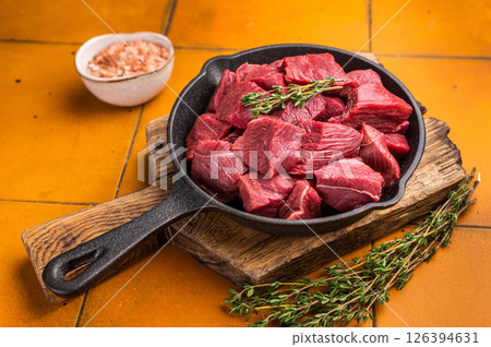 Ready for cooking Diced Elk meat, raw Game Meat in a pan. orange background. top view 126394631