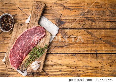 Raw rump cap steak, uncooked beef meat, showcasing its rich marbling and vibrant color. wooden background. top view 126394660