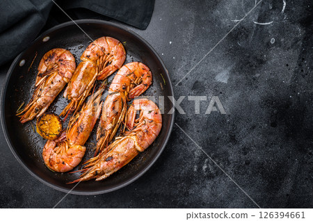 Pan fried red Argentine shrimps, Prawns Langostino Austral with herbs. black background. top view 126394661