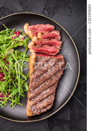 BBQ roast Rump Cap beef steak, Brazilian Picanha with salad on a plate. black background. top view 126394664