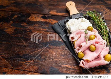 Italian antipasto with Sliced Prosciutto Cotto ham, green olives and mozzarella. wooden background. top view 126394685