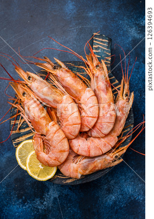 Ready for cooking Red Argentine shrimps, raw Prawns Langostino Austral on wooden board. blue background. top view Ready for cooking Red Argentine shrimps, raw Prawns Langostino Austral on wooden board. blue background. top view 126394693