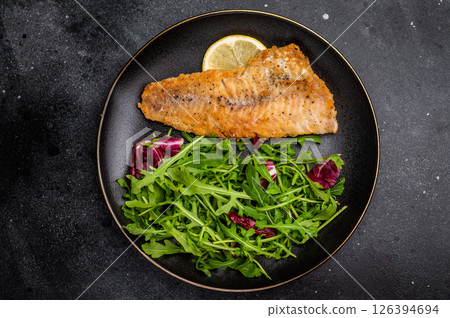 Roasted Haddock fish fillet on a plate with salad. black background. top view Roasted Haddock fish fillet on a plate with salad. black background. top view 126394694