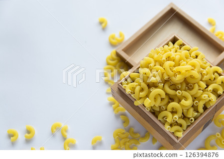 Italian food concept and menu design with copy space. Uncooked yellow pasta in wood box. Flat lay. 126394876