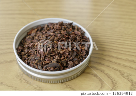Pile of instant granulated cocoa nibs on a wooden table 126394912