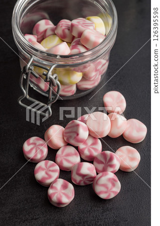 Colorful striped candies on black table. 126395598